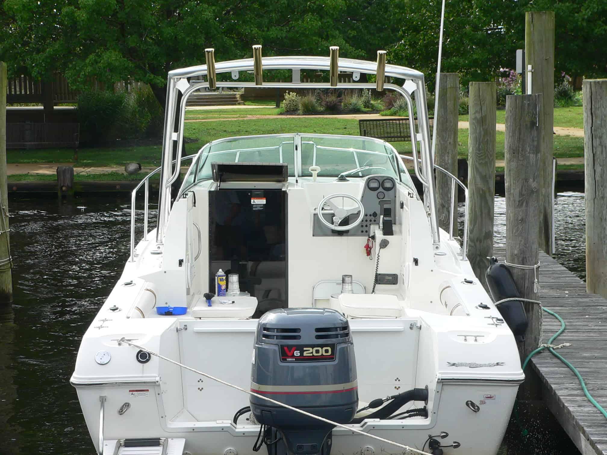 Atlantic Towers Top installed on a Wellcraft 23/24 Walk boat, docked by a wooden pier with trees in the background.