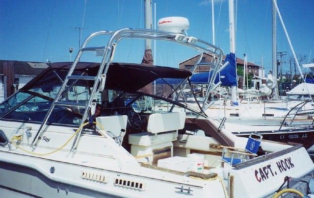 Atlantic Towers Arch installed on a Sea Ray 300 Sundancer boat at a marina with other boats in the background.