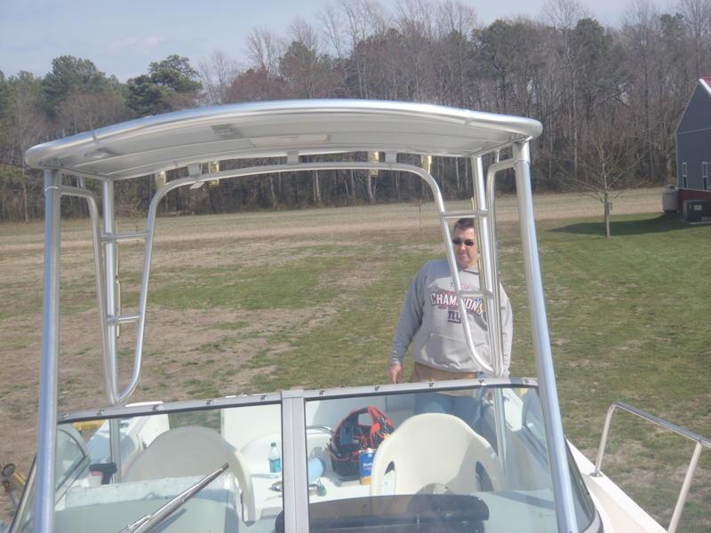 Atlantic Towers Top installed on a white and blue Trophy 2352/2302 walkaround boat docked on water with calm waves.