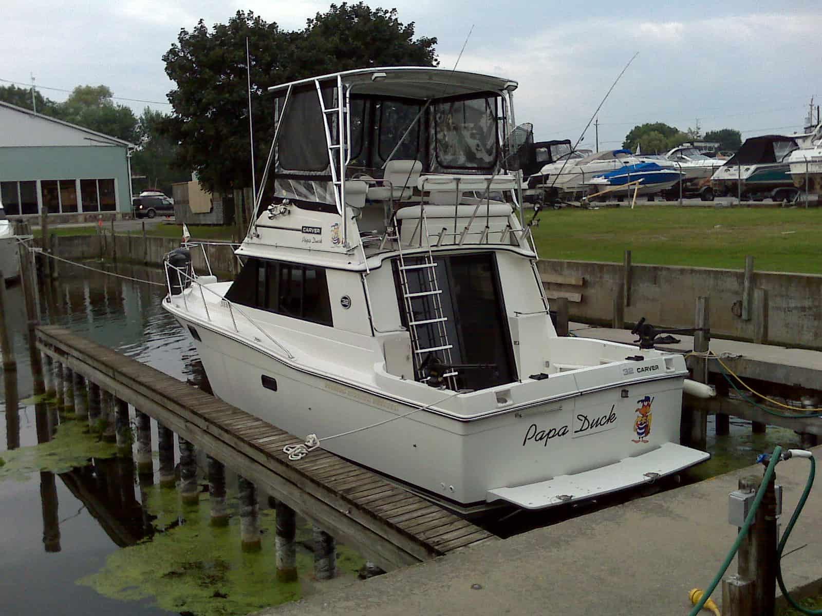 Atlantic Towers Top installed on a Carver 32 Convertible boat, docked with reflection in the water.
