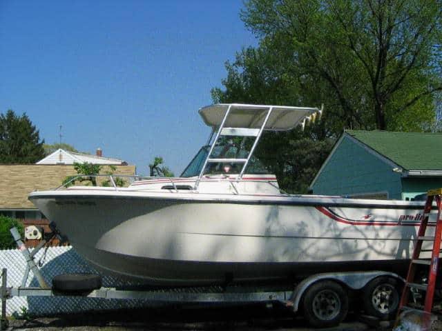 Pro Line 21 Walk around boat with Atlantic Towers Top mounted on trailer in residential area under blue sky