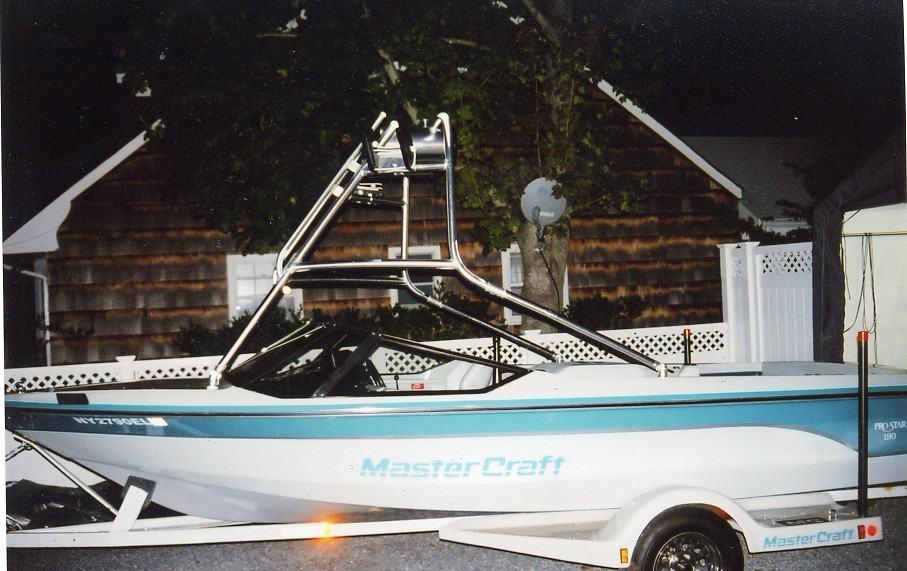 Mastercraft Prostar 190 boat with a chrome Atlantic Towers Air Tower installed, on a trailer at night.