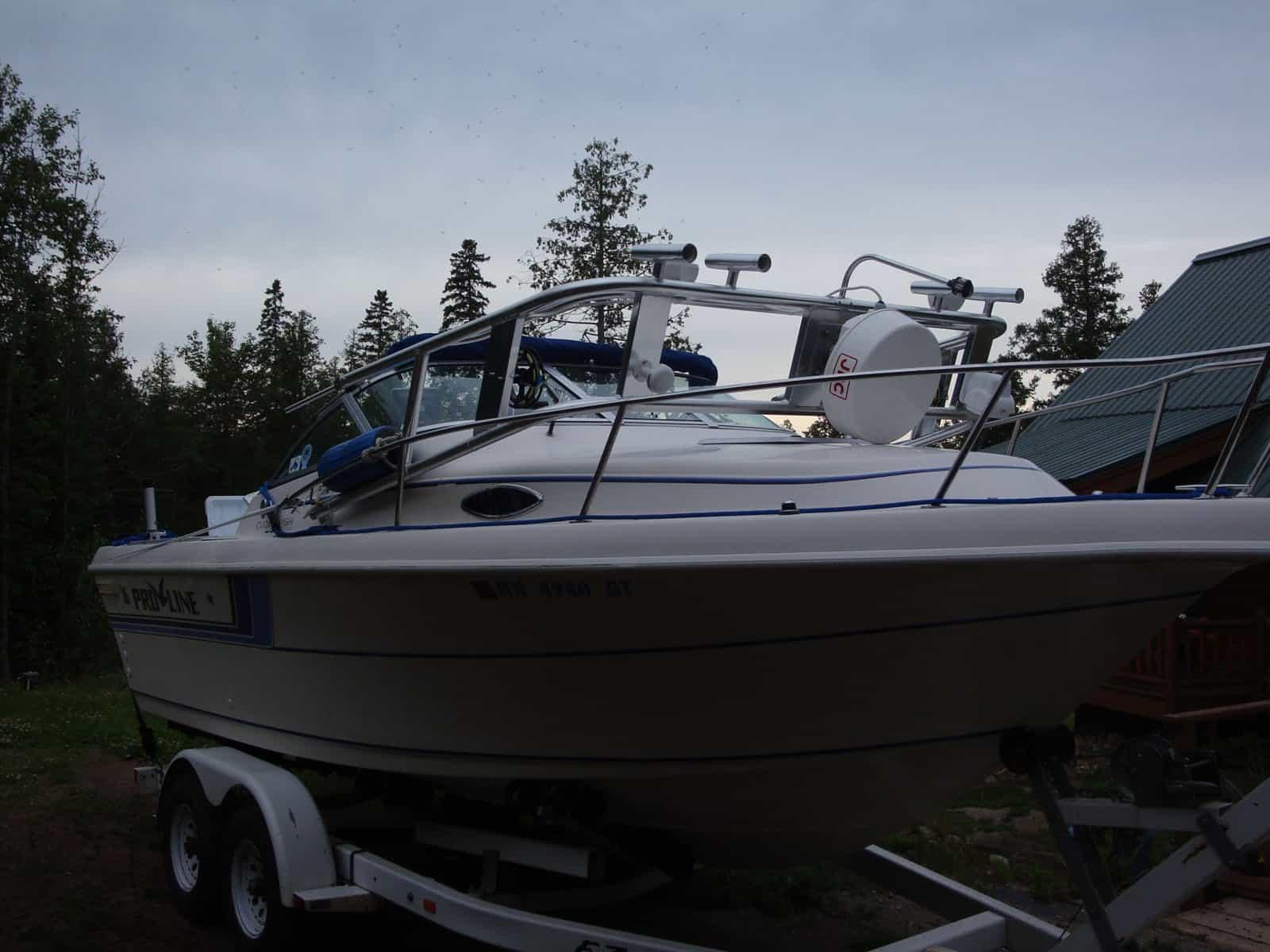 Atlantic Towers Arch installed on a Pro Line 220 Cuddy Fish boat parked on a trailer amidst wooded surroundings.