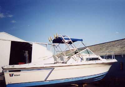 Atlantic Towers Arch installed on a Wellcraft 250 Sportsman/ Coastal boat, docked near a shed.