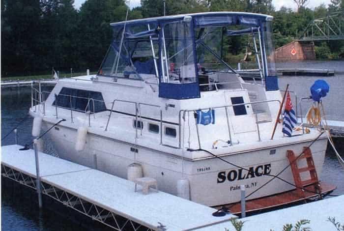 Trojan Tri-Cabin boat docked with a blue Atlantic Towers Top installed over the cockpit area.