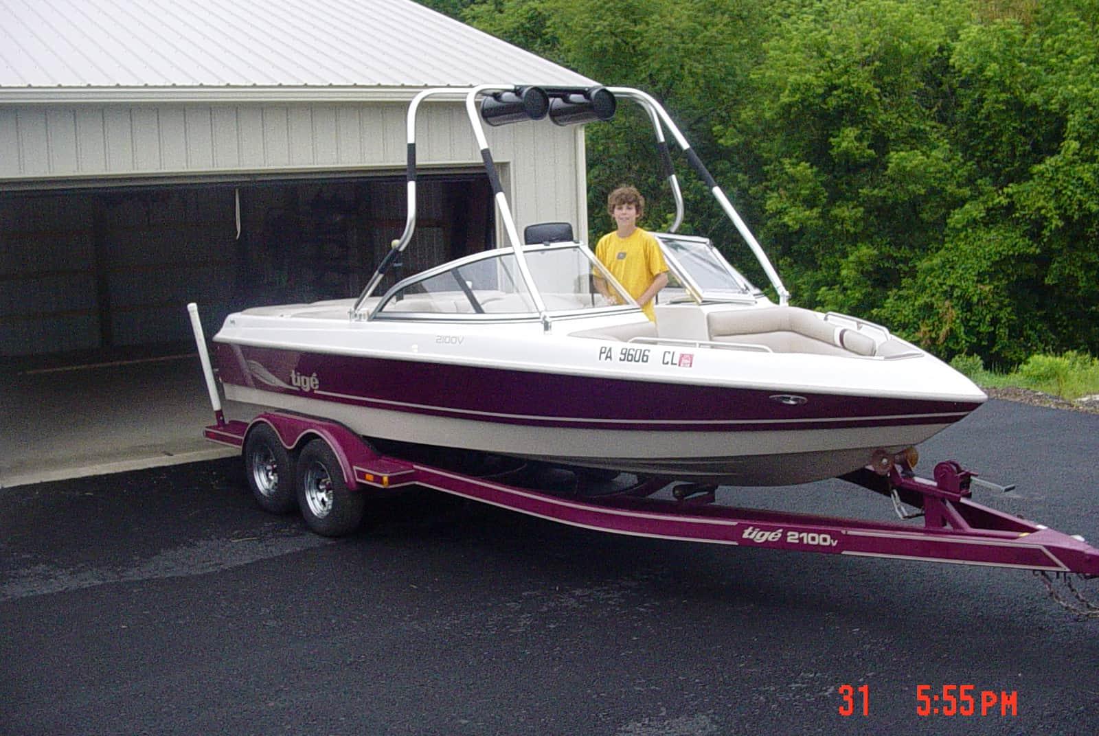 Atlantic Towers Air Tower installed on a Tige 2100V boat, parked on a driveway beside a garage.