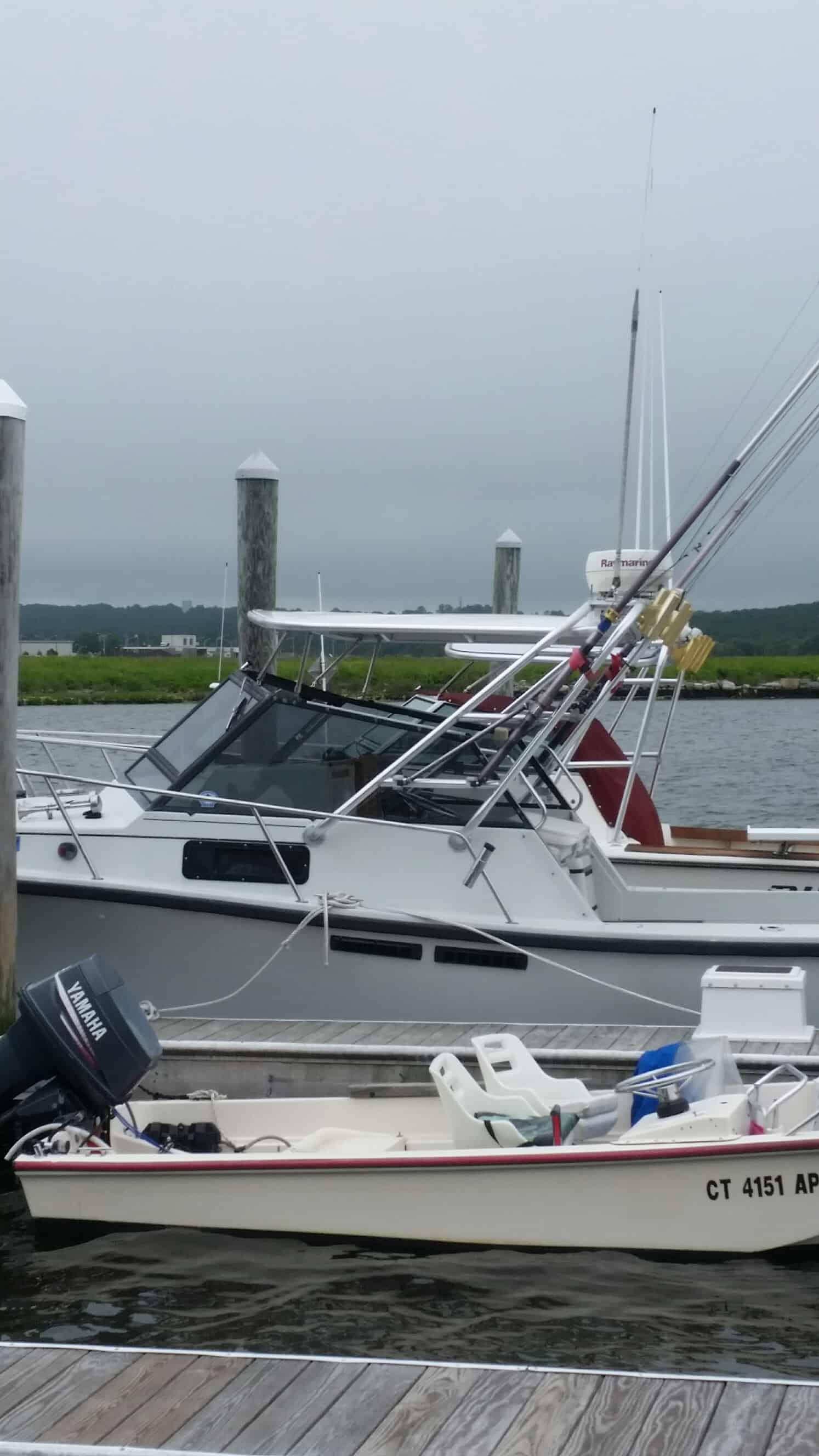 Rampage boat docked with Atlantic Towers Top installed, featuring fishing rods and a Yamaha outboard motor nearby.