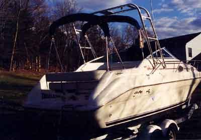 Atlantic Towers arch installed on a white Sea Ray 250 Sundancer boat parked on a trailer near a house and trees.