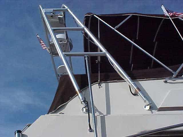 Atlantic Towers Arch installed on Carver 2896 Mariner boat with metal rails and black canopy under a blue sky.