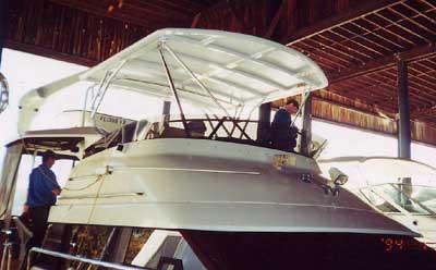 Atlantic Towers Top installed on Silverton 41 Aft Cabin yacht under a large wooden canopy with two people aboard the boat.
