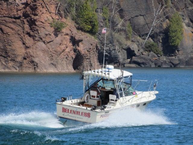 Atlantic Towers Top installed on a Pursuit 2700 Open boat cruising in a scenic waterway.
