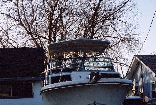 Atlantic Towers Top installed on a Stamas V24 boat, viewed from the front with trees in the background and houses nearby.