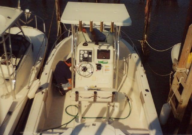 Seaswirl 2100 Console boat equipped with Atlantic Towers T-Top docked with two people working on the deck
