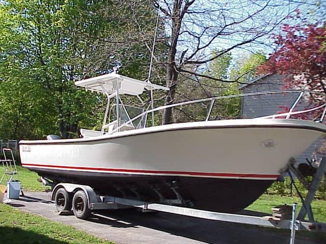 Master Marine Good Go boat on trailer with Atlantic Towers T-Top installed, parked on grass near trees and house.