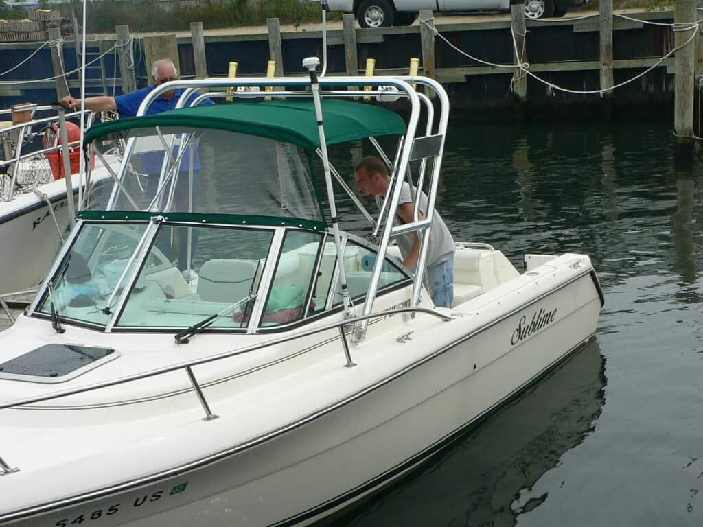 Atlantic Towers Arch installed on a Pursuit 2260 Denali boat at the dock with a person on board.