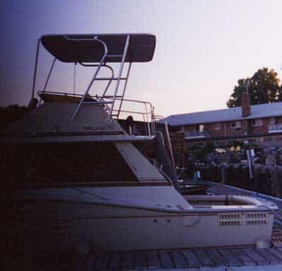 Atlantic Towers Top installed on a Trojan 36 Convertible boat at a marina during sunset.