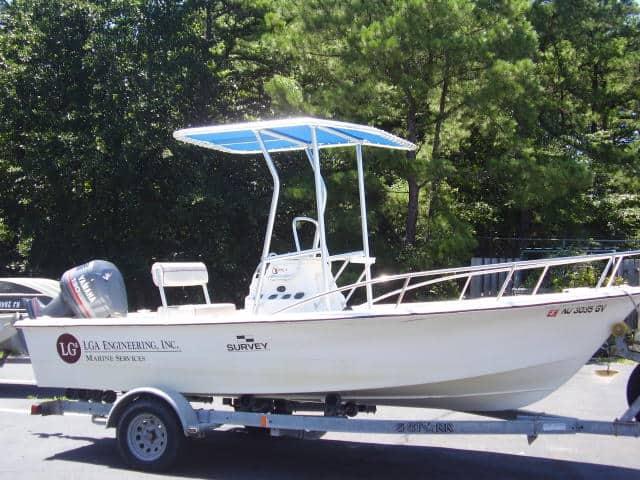 Atlantic Towers T-Top installed on a C-Hawk 18 center console boat, parked on a trailer among trees.