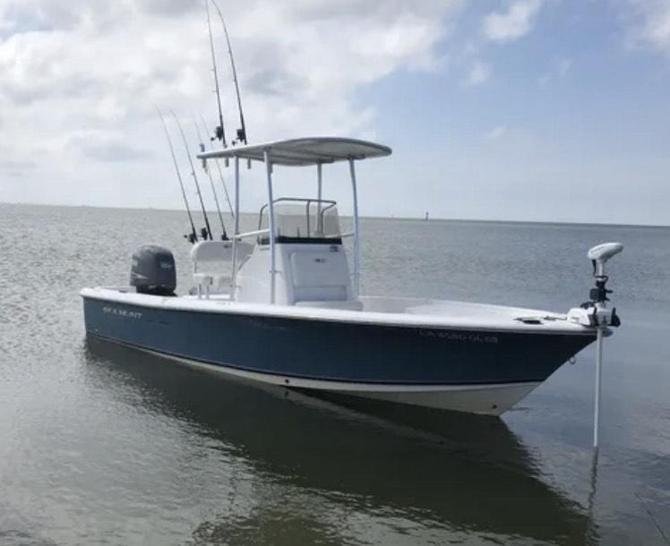 Atlantic Towers T-Top installed on a Sea Hunt boat, anchored in calm waters with fishing rods visible.