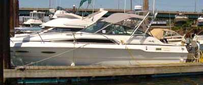 Side view of a Sea Ray 300 Sundancer boat docked, equipped with an Atlantic Towers Arch above the cockpit.