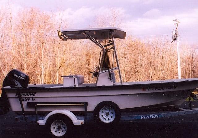 Atlantic Towers T-Top installed on a Maritime Skiff boat parked on a Venture trailer with trees in the background.
