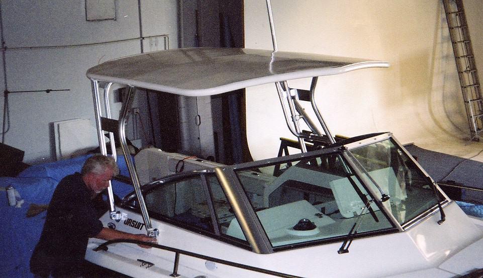 Atlantic Towers Top installed on a Pursuit 2460 Denali boat, with an individual adjusting the equipment.