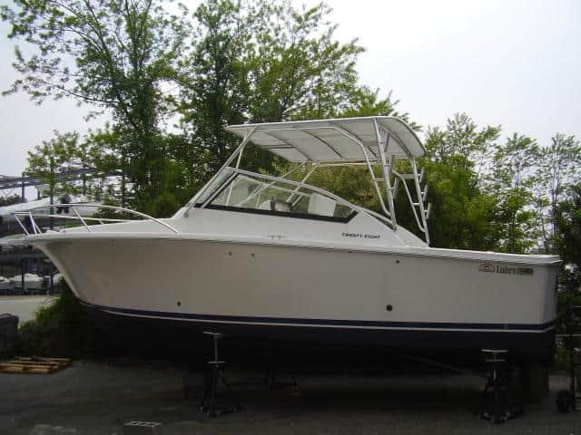 Luhrs 28 Open boat with Atlantic Towers Top installed, shown on stands outdoors near trees.