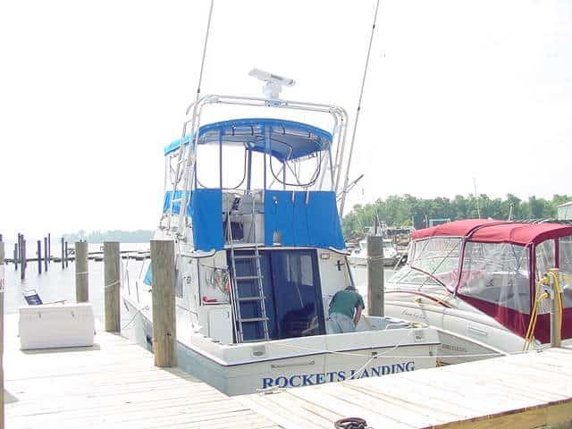 Atlantic Towers Arch installed on a Carver 32 Convertible boat at the dock, with surrounding vessels and marina.