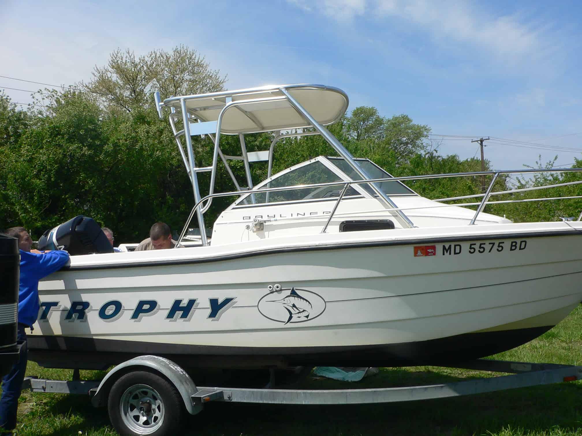 Trophy 1802 Walkaround boat on trailer with installed Atlantic Towers Top canopy and three people aboard.