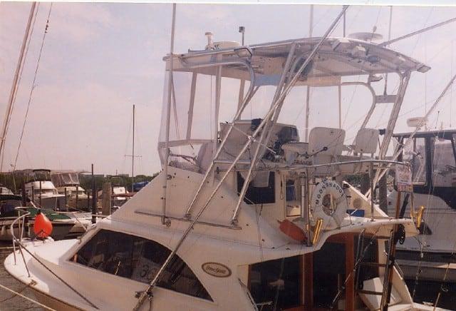 Ocean 29SS motorboat with installed Atlantic Towers Top, docked in a marina with other boats in the background.