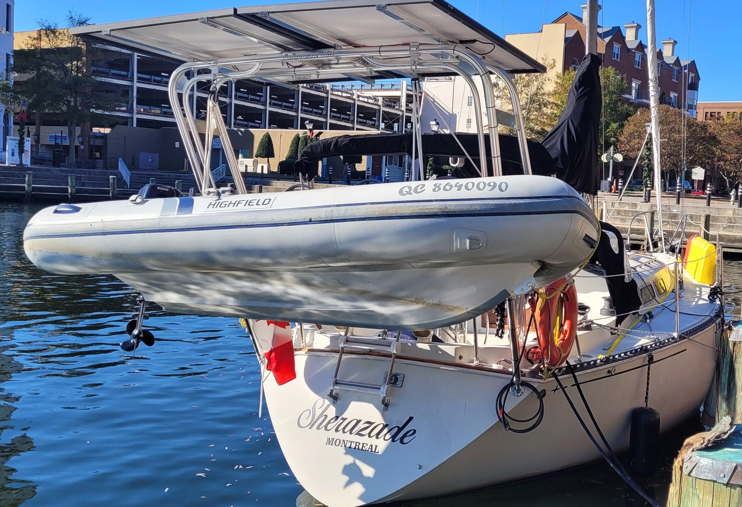 Atlantic Towers Arch installed on a sailboat with a Highfield dinghy on a calm water surface in a harbor setting.