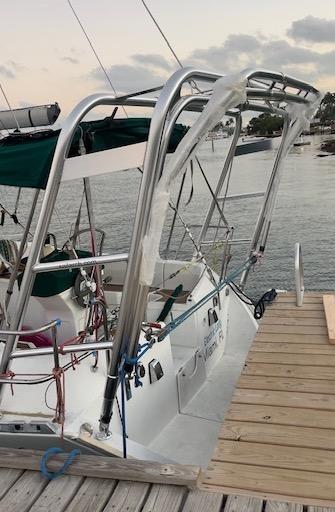 Atlantic Towers Arch installed on a Beneteau sailboat docked at a wooden pier with water and shoreline in the background.