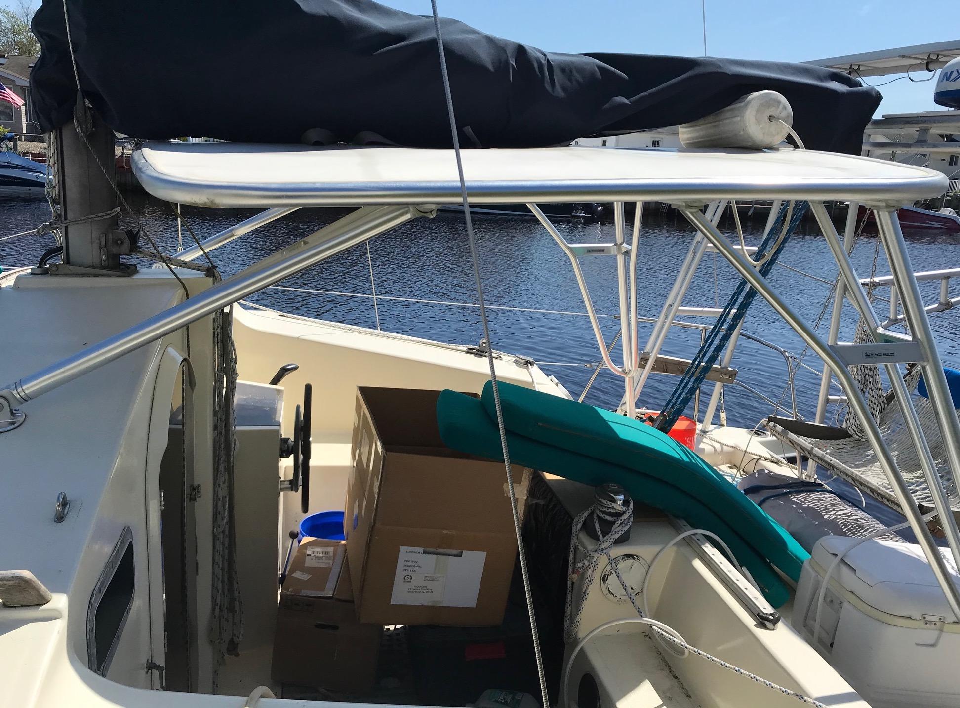 Atlantic Towers Top installed on a sailing boat's deck, with storage boxes and cushions visible in the cockpit area.