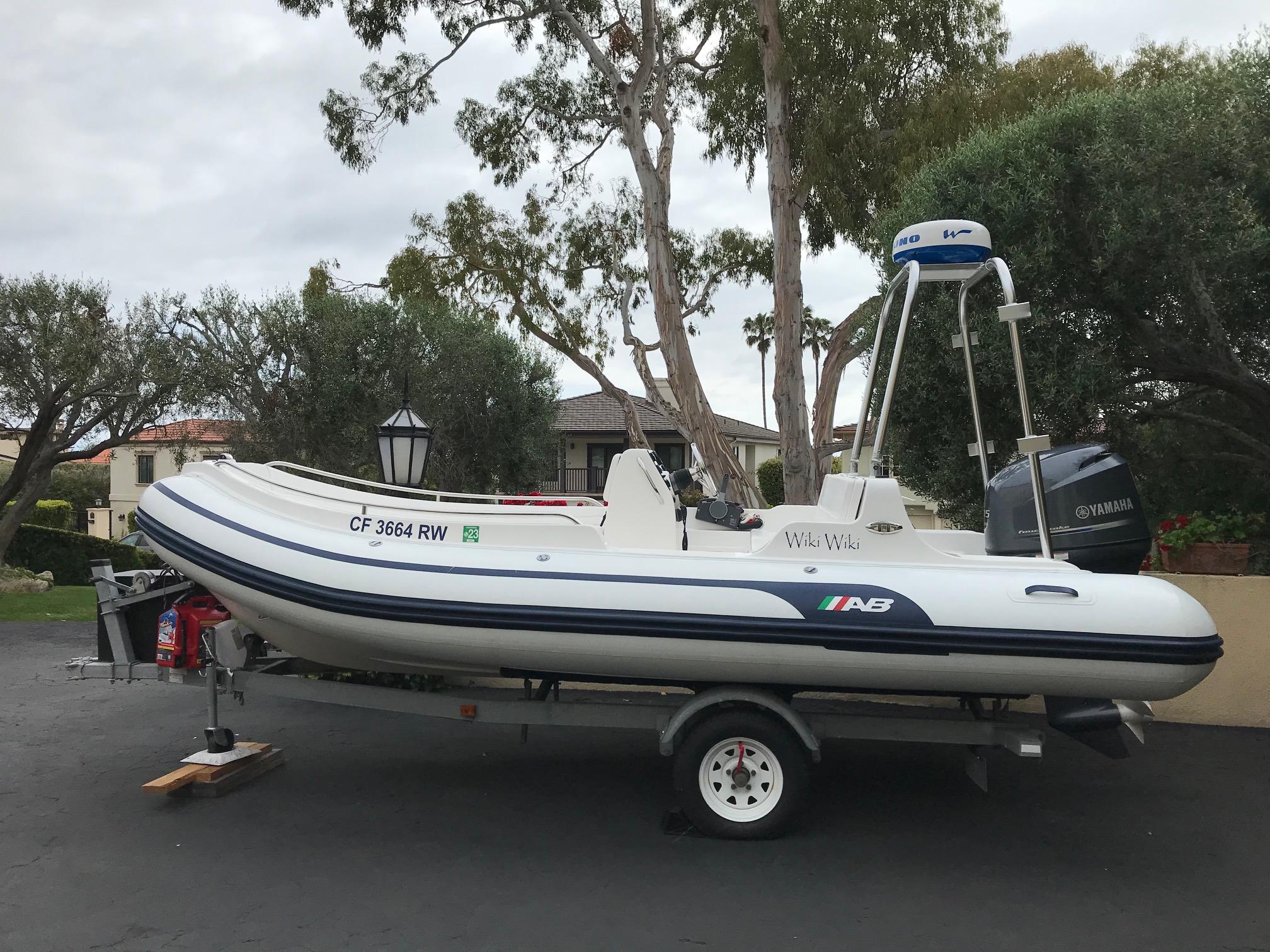 Atlantic Towers Arch installed on an AB Inflatables boat, parked with a trailer in a residential area.