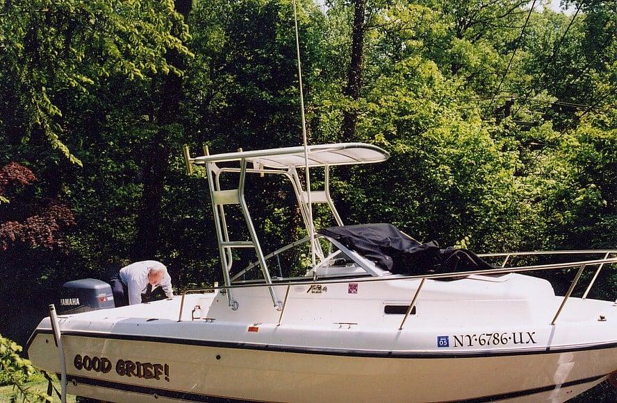 Atlantic Towers Top installed on a Century 2100 W/A boat with a person working on the deck amidst a forested background.