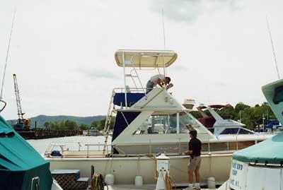 Atlantic Towers Top installed on a Chris Craft 38 Commander boat with two people working on it docked at a marina.