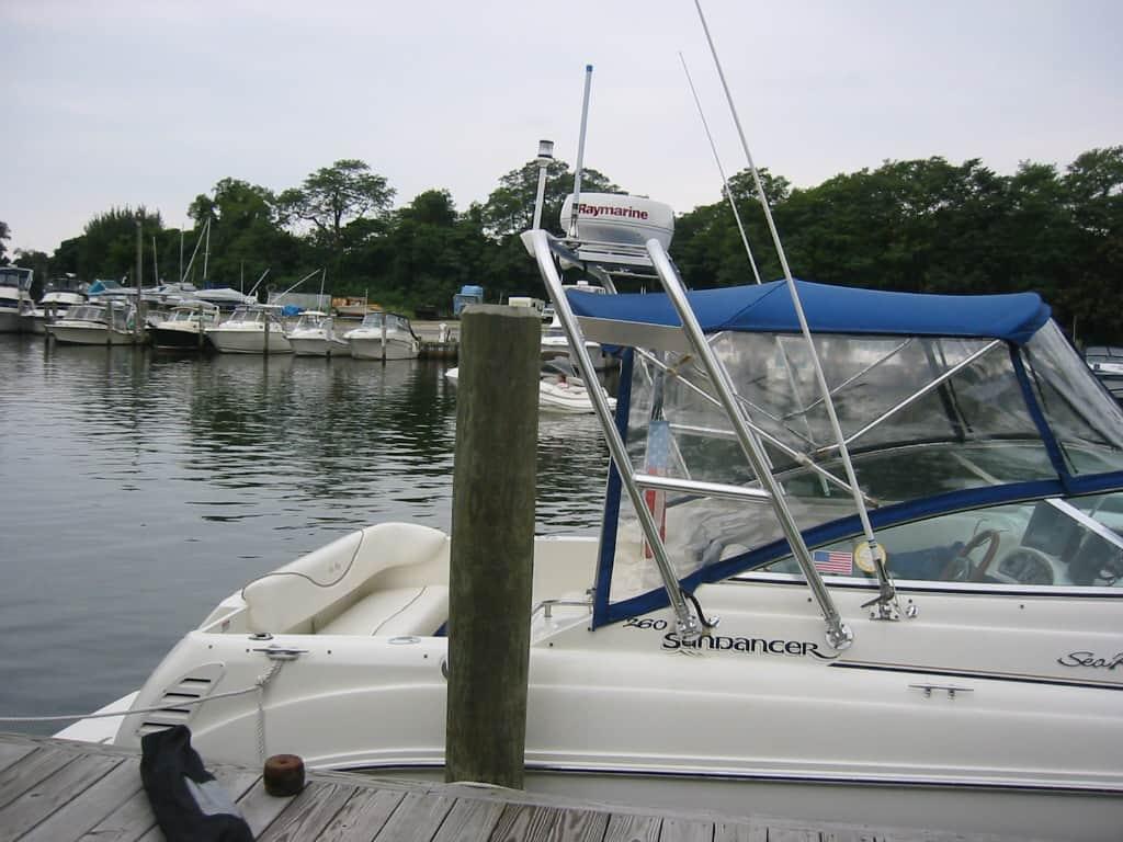 Side view of Sea Ray 260 DA boat docked with Atlantic Towers Arch installed and canopy with clear side panels.