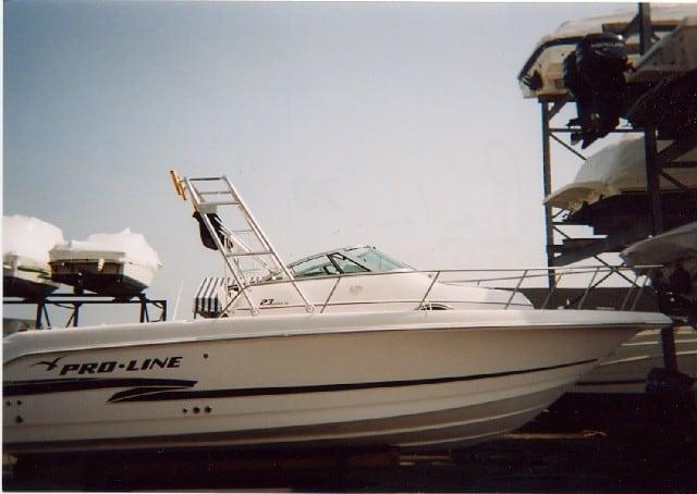 Pro Line 23 Walkaround boat with installed Atlantic Towers Arch visible on the deck, docked near stacked boats.