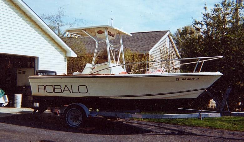 Atlantic Towers T-Top installed on a Robalo boat, parked on a trailer beside a house.