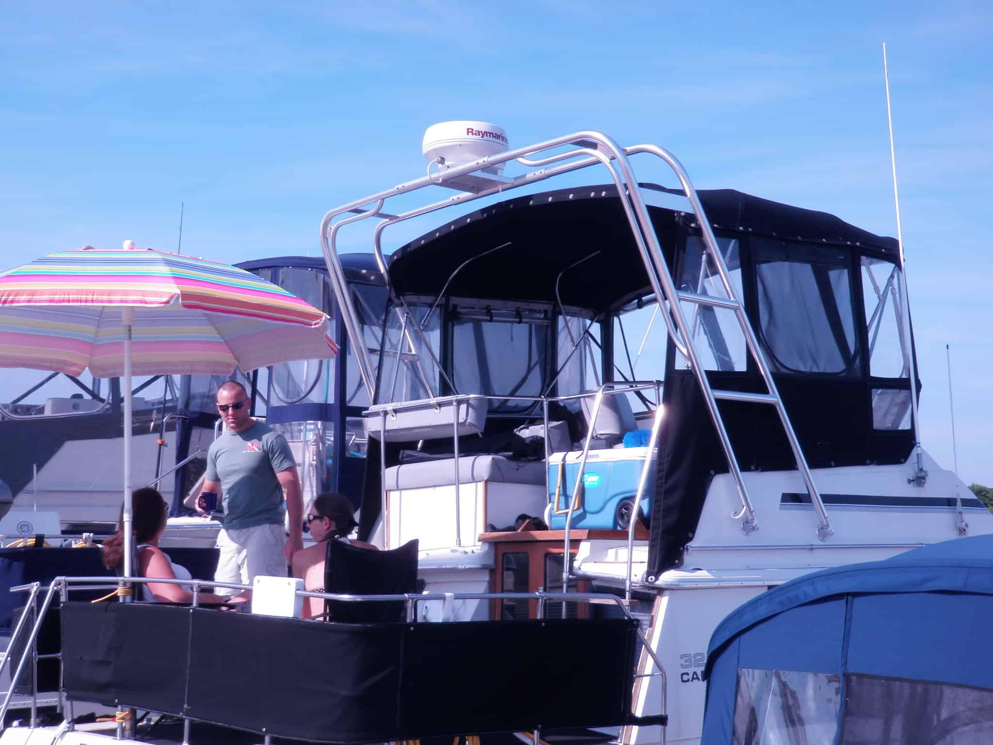 Atlantic Towers Arch installed on a Carver 3207 Aft Cabin boat, with people socializing and an umbrella in view.