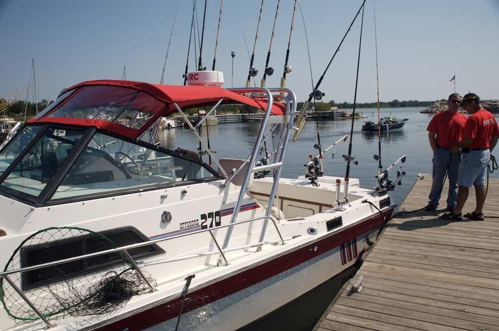Atlantic Towers Arch installed on a Sportcraft 270 boat docked by the water with fishermen in the background.