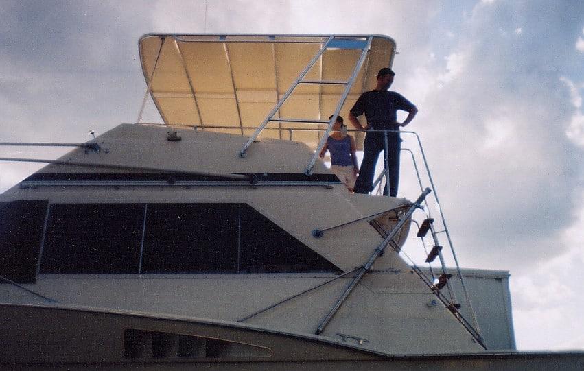 Atlantic Towers Top installed on a Chris Craft Commander FB, featuring two people on deck against a cloudy sky.