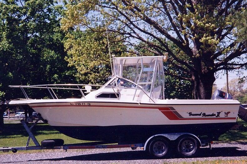 Atlantic Towers Top installed on a Celebrity 210 Fish Hawk boat, parked on a trailer under trees.