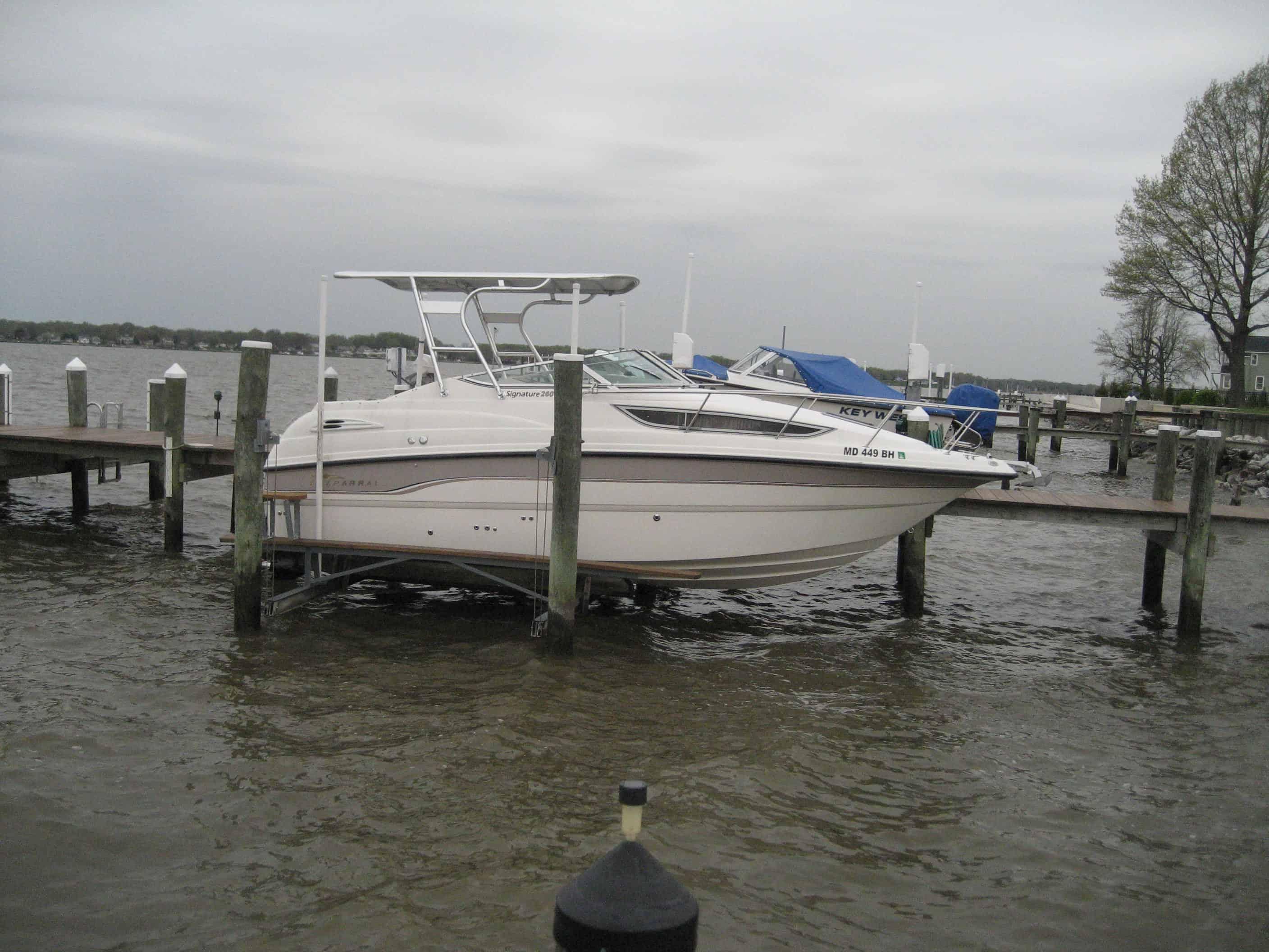 Atlantic Towers Top installed on a Chaparral boat docked at a marina amid calm waters and cloudy skies.