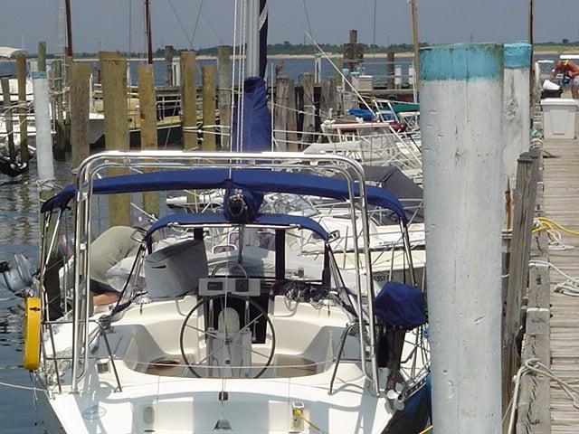 Atlantic Towers Arch on a Dufour Yachts 38 Classic docked at a marina, surrounded by other boats and pilings.