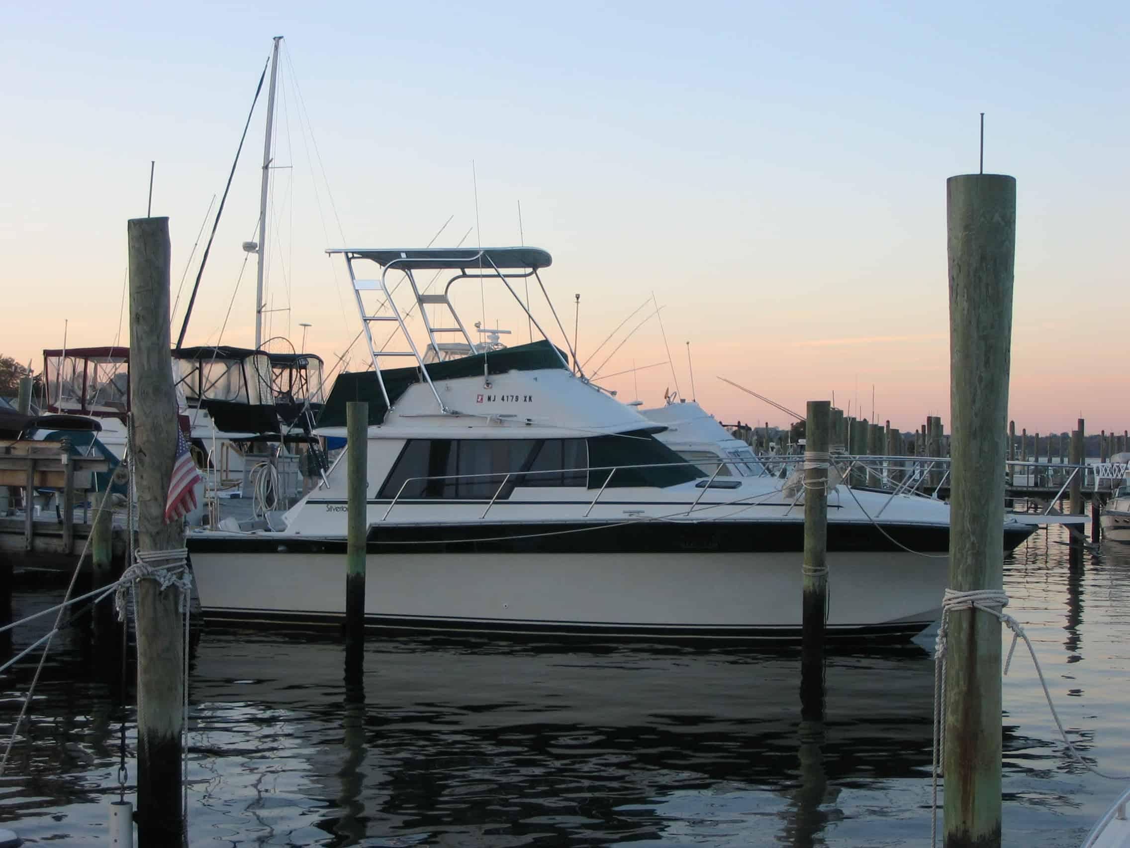 Silverton 34 Convertible boat docked at marina during sunset with installed Atlantic Towers Top frame above helm.