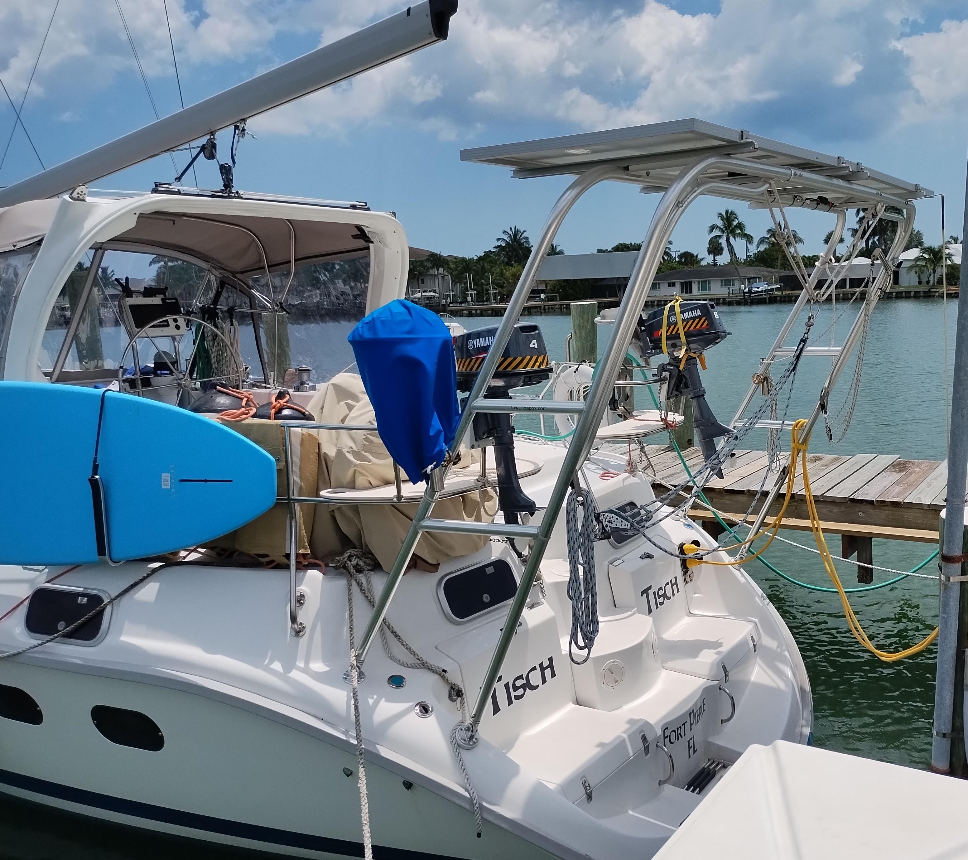 Hunter sailboat docked with Atlantic Towers Arch installed on the stern, equipped with solar panels and two outboard Yamaha engines.
