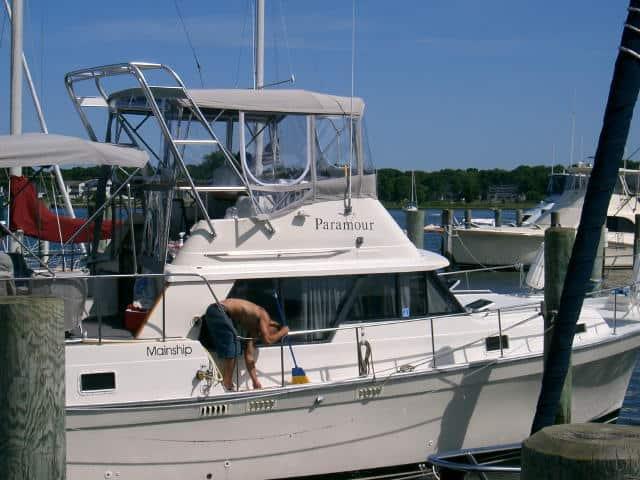 Atlantic Towers Arch installed on a Mainship 36 Aft Cabin boat at the dock with a person cleaning the deck.