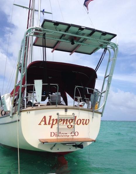 Atlantic Towers arch installed on the back of a sailboat named Alpenglow, with a clear sky and water in the background.