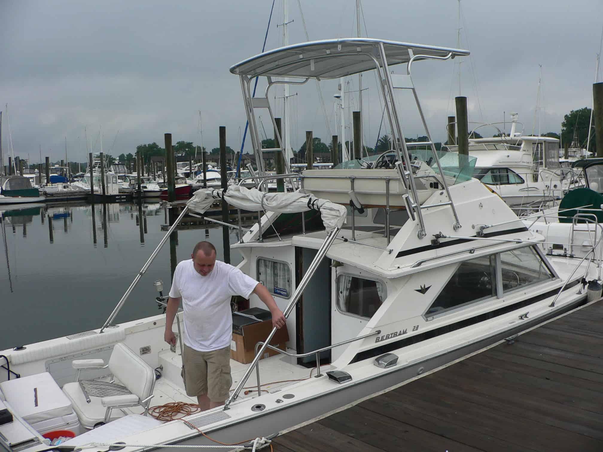 Atlantic Towers Top installed on a Bertram 28 Flybridge Cruiser at a marina, with reflections on the water.