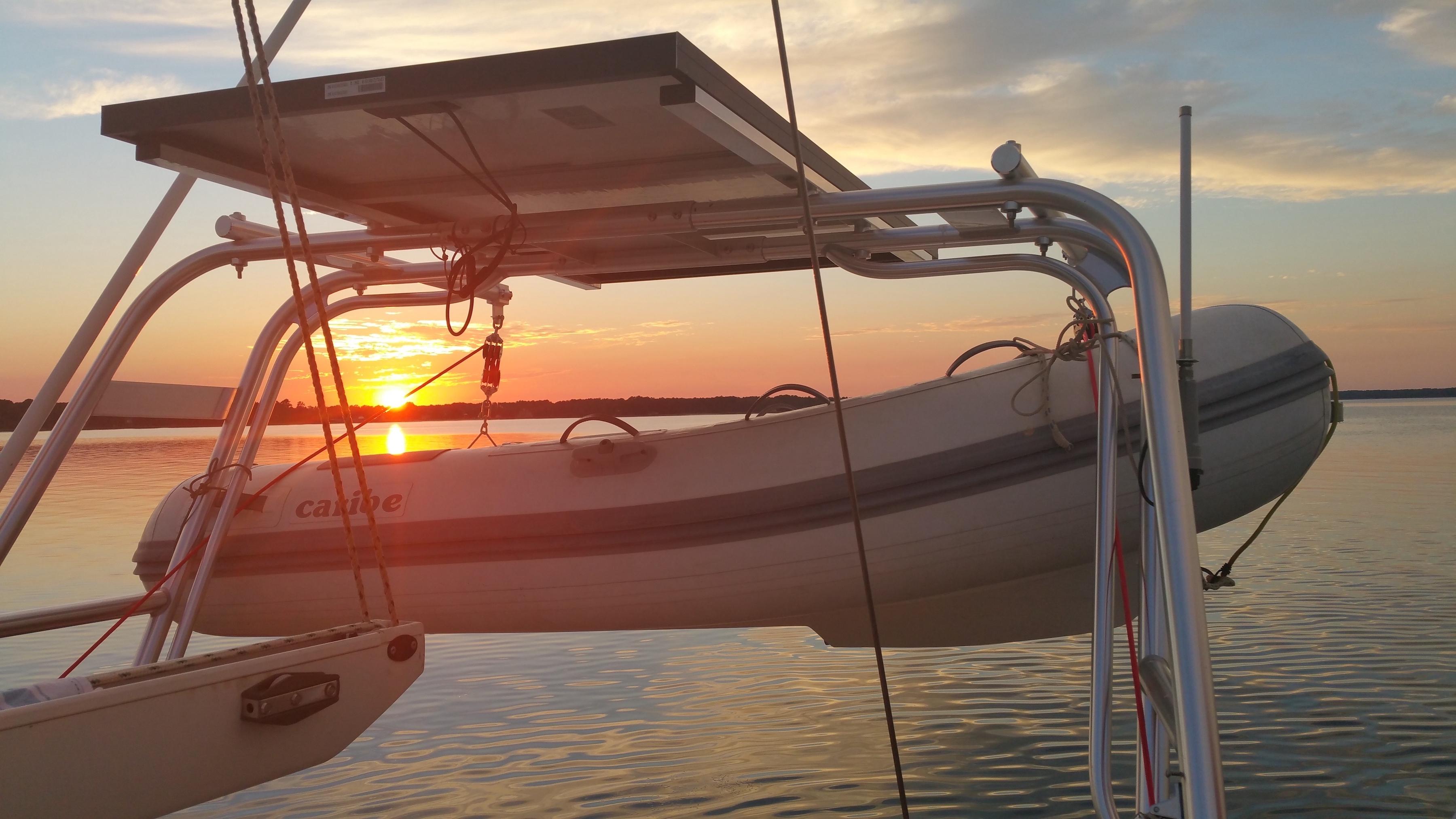 Atlantic Towers Arch with mounted solar panel and inflatable boat hanging at sunset over calm water.